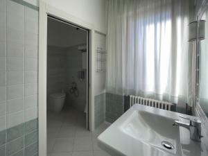 a white bathroom with a sink and a shower at La Lanterna in Silvi Marina