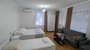Habitación pequeña con 2 camas y sofá en Park Avenue Kobuleti, en Kobuleti