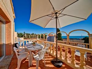 a table and chairs on a balcony with an umbrella at Apartment Canuta Baja-8 by Interhome in La Canuta