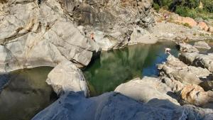 a group of people swimming in a body of water at Casetta del cuore intero appartamento con camino in Sadali