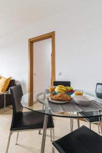 un tavolo di vetro con un piatto di banane sopra di Home2Book Comfy Apartment Siete Palmas a Las Palmas de Gran Canaria