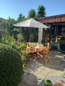 un patio con mesa y sombrilla en Osborne Lodge en Ryde