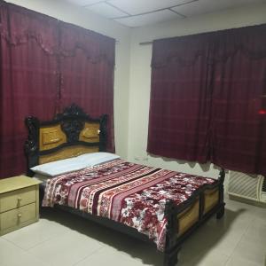 Schlafzimmer mit einem Bett mit roten Vorhängen in der Unterkunft HOTEL PRIMAVERA in Guayaquil