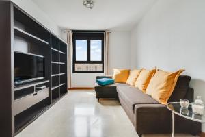 a living room with a couch and a tv at Home2Book Comfy Apartment Siete Palmas in Las Palmas de Gran Canaria