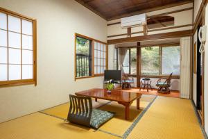 a living room with a wooden table and chairs at 宿坊 志摩房 - Temple Hotel Simanobo in Minobu