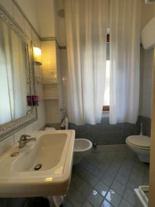 a white bathroom with a sink and a toilet at La Lanterna in Silvi Marina