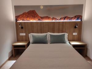a bedroom with a large bed with a wooden headboard at Hostal Nadal in Sóller