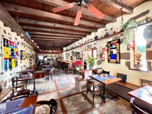 a restaurant with tables and chairs in a room at Doble clásica con desayuno, Wifi y hermosa piscina en Yaiza in Yaiza