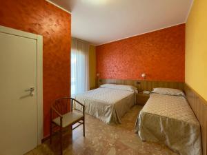 a room with two beds and a chair in it at La Lanterna in Silvi Marina
