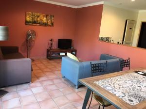 - un salon avec deux canapés bleus et une table dans l'établissement Le Mas Mérindol Gîte Ventoux, à Loriol-du-Comtat