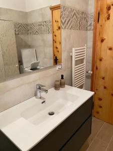 y baño con lavabo blanco y espejo. en Fiordaliso en Santo Stefano dʼAveto