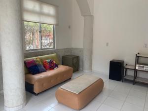 a living room with a couch and a window at Casa do Sol Fortaleza in Fortaleza