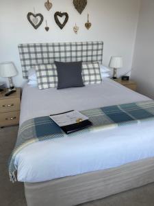 a bedroom with a bed with a book on it at Nythfa Guest House in Saundersfoot