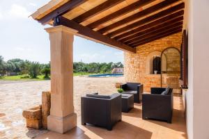 un patio al aire libre con sillas y pérgola en Sa Atalaya Vella, en Santanyí
