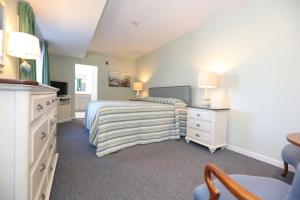 1 dormitorio con 1 cama con colcha a rayas en The Heritage Inn, en Cape May