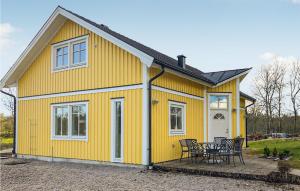 een geel huis met een tafel ervoor bij Awesome Home In Ronneby With Kitchen in Ronneby