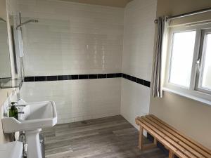 a bathroom with a sink and a window at Pool House, farm stay in Brackley