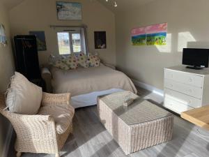 a bedroom with a bed and a couch and a table at Pool House, farm stay in Brackley