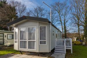 a small white tiny house with a porch at Mowbreck Park in Kirkham