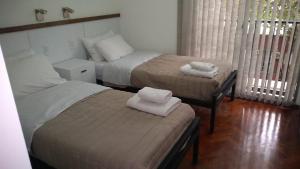 1 dormitorio con 2 camas, mesa y silla en Amplio departamento Balcon pleno centro Peatonal en Mendoza