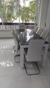 una mesa de comedor con sillas blancas alrededor en Amplio departamento Balcon pleno centro Peatonal en Mendoza