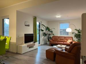 Der Falkenhorst في باد ساخسا: غرفة معيشة بها أريكة وتلفزيون