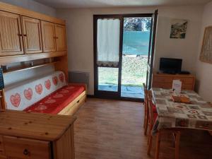 a small room with a bed and a table and a window at Studio Valloire, 1 pièce, 4 personnes - FR-1-263-18 in Valloire