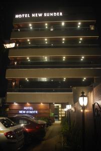 a hotel with cars parked in front of it at night at Hotel New Sunder in Indore