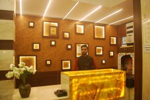a man standing behind a podium in a room at Hotel New Sunder in Indore
