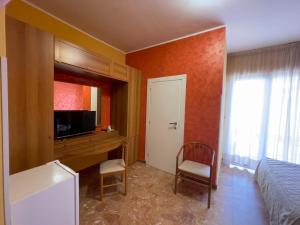 a bedroom with a bed and a desk and a television at La Lanterna in Silvi Marina