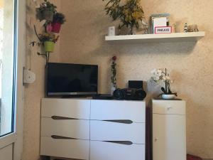 una cassettiera bianca con sopra una televisione di Appartement Port Fréjus avec Loggia et accès Plages à pieds a Fréjus
