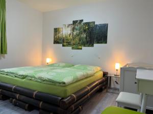 a bed in a room with three paintings on the wall at Der Falkenhorst in Bad Sachsa