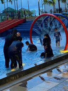 a group of people in the water at a swimming pool at Js homestay in Melaka +1 photo