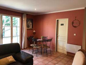 sala de estar con mesa y sillas en Le Mas Mérindol Gîte Cerise, en Loriol-du-Comtat