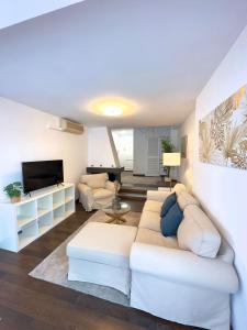 a living room with a white couch and a tv at Apartamento Puerto Banus in Marbella