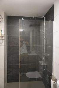 a person taking a picture of a shower in a bathroom at BaruHaus urbanizacion con piscina Villamañan 