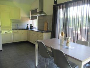 a kitchen with a wooden table and chairs and a dining room at Comfortabel Vakantiehuis aan Zee én Méér ! in Kamperland