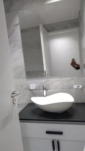 a white sink on a black counter in a bathroom at Amplio departamento Balcon pleno centro Peatonal in Mendoza