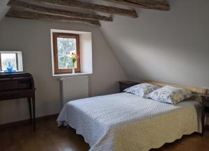 a bedroom with a bed and a window at LE PARDÈS BnB in Rocamadour