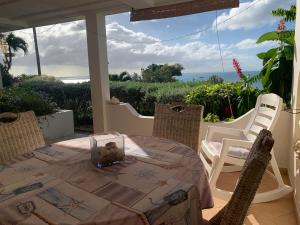 a table on a patio with a view of the ocean at Vista Mare in Dickenson Bay