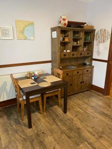 une salle à manger avec une table, des chaises et une armoire dans l'établissement Nythfa Guest House, à Saundersfoot