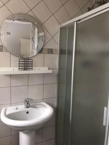 uma casa de banho com um lavatório e um espelho em A Touch of Red em Oudtshoorn