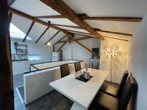 a kitchen and dining room with a white table and chairs at GLEIS 13 - THE LOFT im ehemaligen Lokschuppen in Bückeburg