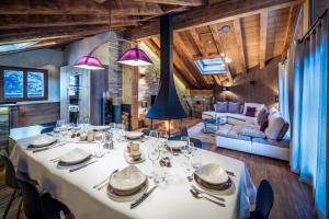 a dining room with a table and a couch at Chalets Tâmo in Courchevel