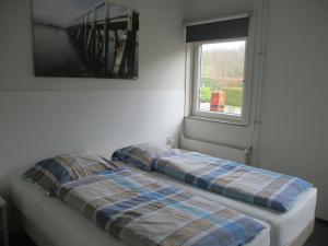 two beds in a room with a window at Comfortabel Vakantiehuis aan Zee én Méér ! in Kamperland