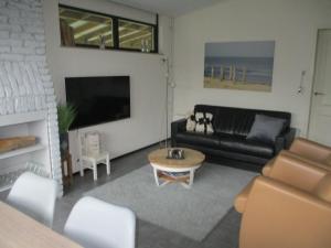 a living room with a couch and a coffee table at Comfortabel Vakantiehuis aan Zee én Méér ! in Kamperland