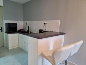 マラッカにあるLuxury Bali Homestayのキッチン(カウンター、シンク、椅子付)