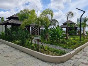マラッカにあるLuxury Bali Homestayの建物前のヤシの木がある庭園