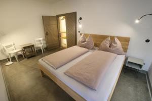 Un dormitorio con una gran cama blanca y una mesa en das ZINIELS, en Sankt Andrä bei Frauenkirchen