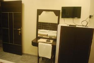 印多尔Hotel New Sunder的一间带镜子的浴室和一张书桌及一台电视 更多24张照片